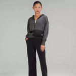 A woman wearing the Lululemon Everywhere Belt Bag 1L in Black around her waist, demonstrating its stylish and functional design for hands-free convenience.
