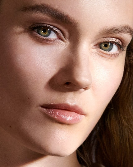 A female model posing with Crème de La Mer, Moisturizing Cream. The white cream is known for its deep hydration and rejuvenating properties, making it a staple in premium skincare routines.