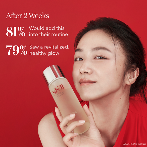 Model holding SK-II PITERA Facial Treatment Essence in hand, demonstrating its convenient size and luxurious packaging.