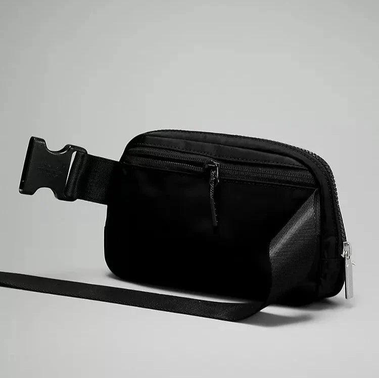 Side view of the Lululemon Everywhere Belt Bag 1L in Black, highlighting its compact and sleek profile, perfect for carrying essentials without bulk.