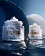 Two front views of Crème de La Mer, Moisturizing Cream, White, showcasing the elegant packaging with the cream popping up. This high-end cream provides rich moisture and helps reduce fine lines.